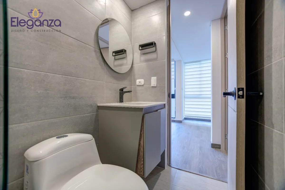 Baño gris espejo redondo mueble suspendido
