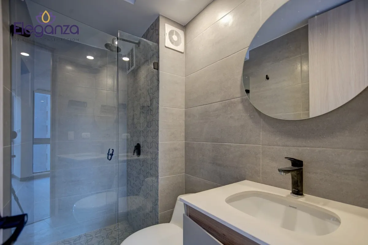 Baño moderno gris ducha vidrio espejo redondo