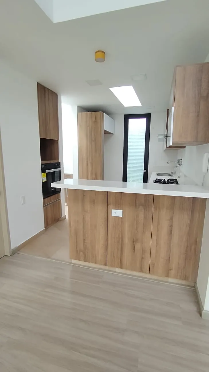 Cocina integral madera clara isla apartamento