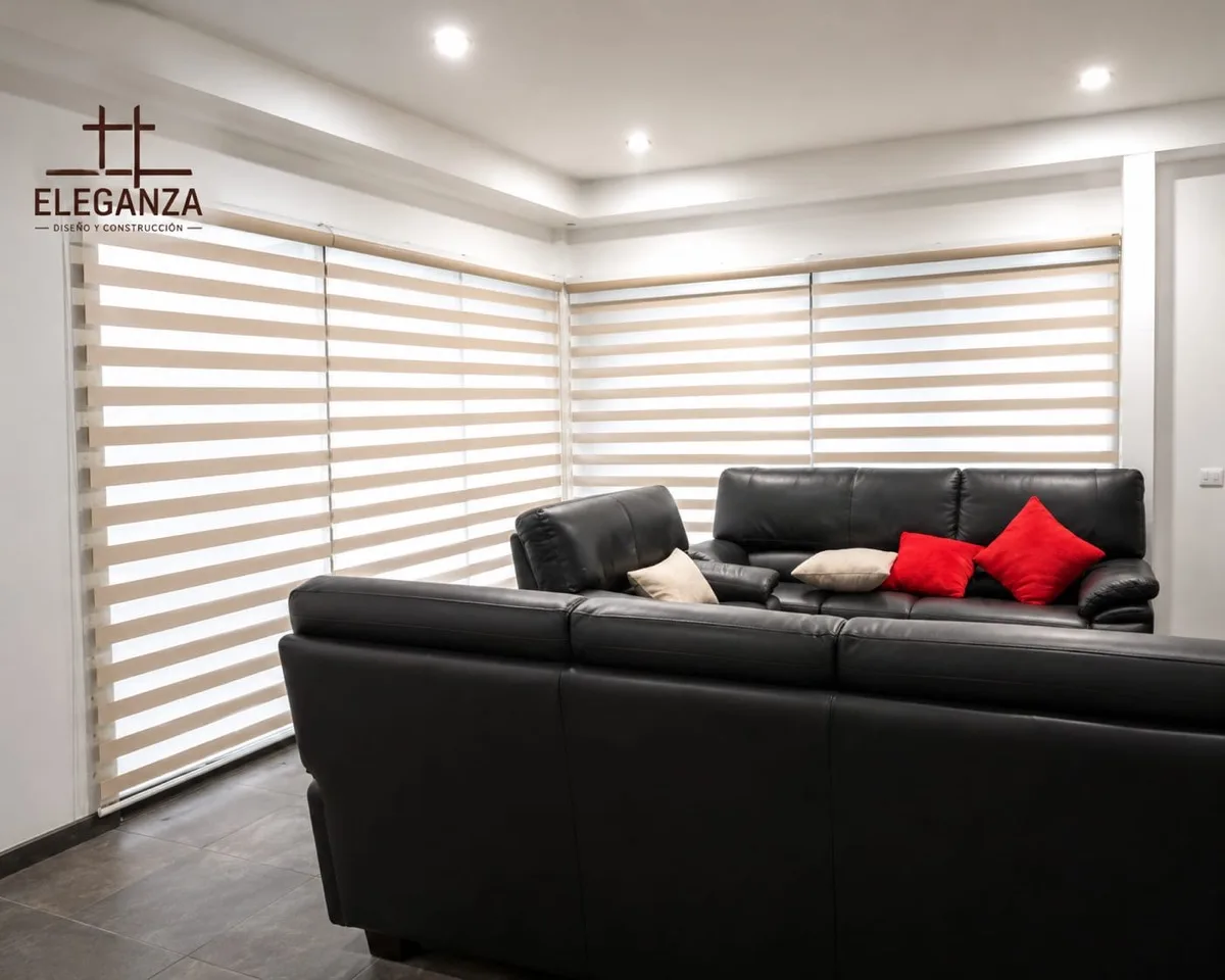 Persiana zebra en sala con sofá negro